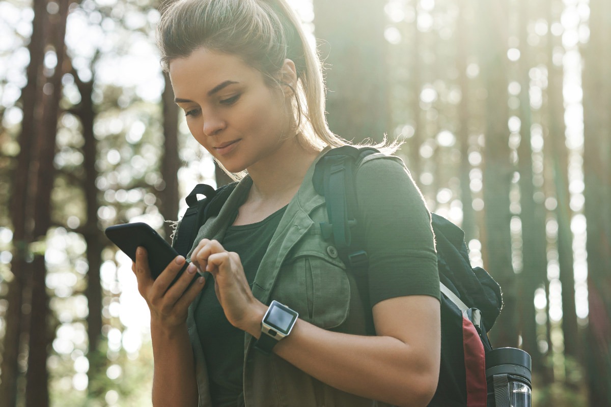 Female walker using her Ordnance Survey App on her mobile phone to check her location on her map.